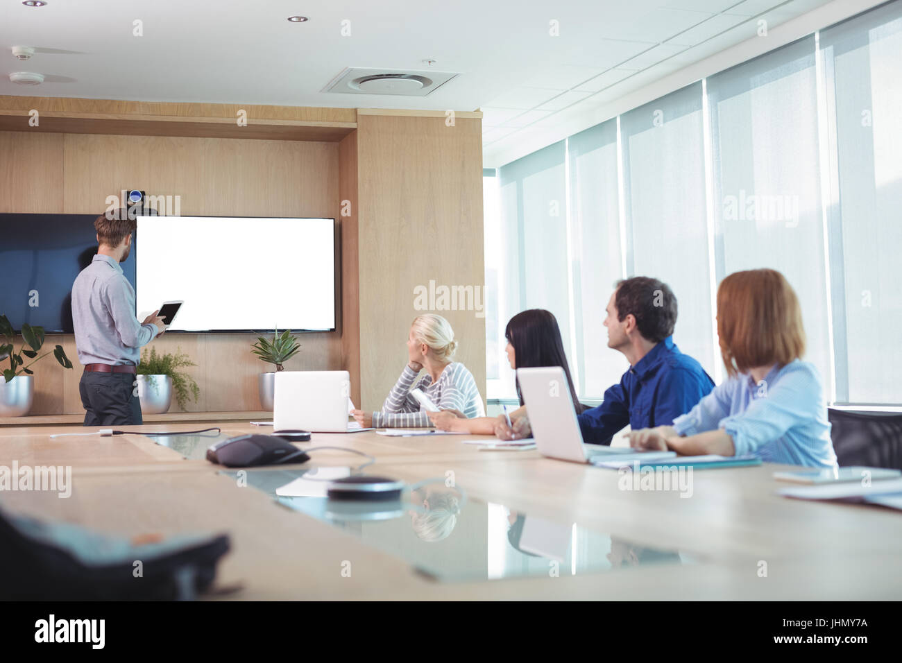 Business people at conference table during meeting in office Stock