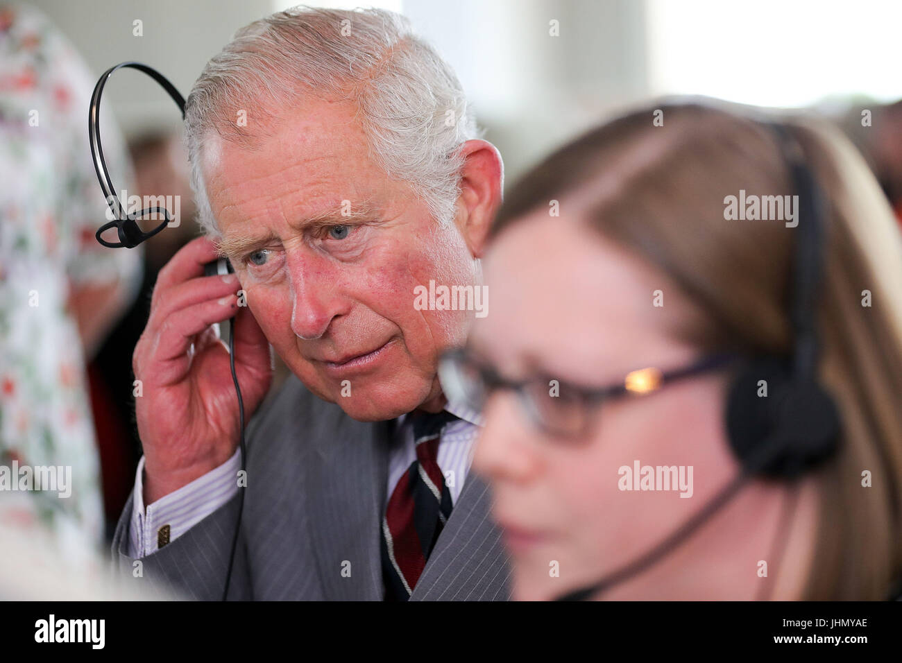 The Prince of Wales listens in to a telephone call with manager Ashley Tatton after he officially opened the new headquarters of Moneypenny, which looks after telephone calls and outsourced digital switchboard services, in Western Gateway, Wrexham. Stock Photo