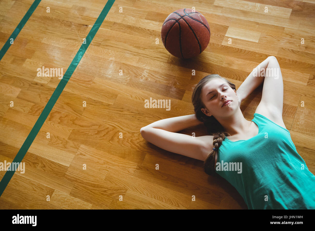 Overhead view of female basketball player sleeping in court Stock Photo