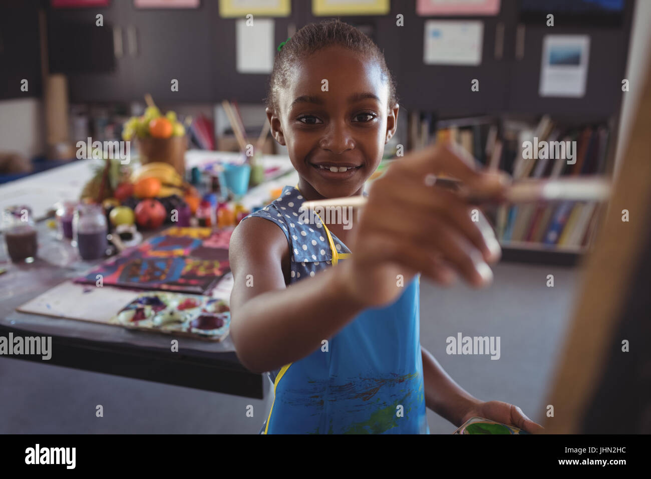 Portrait of happy girl painting on canvas in classroom Stock Photo - Alamy