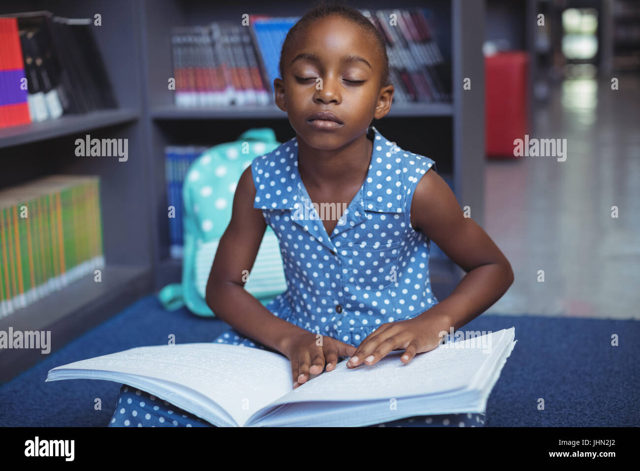 Girl reading braille book while sitting in library Stock Photo Alamy