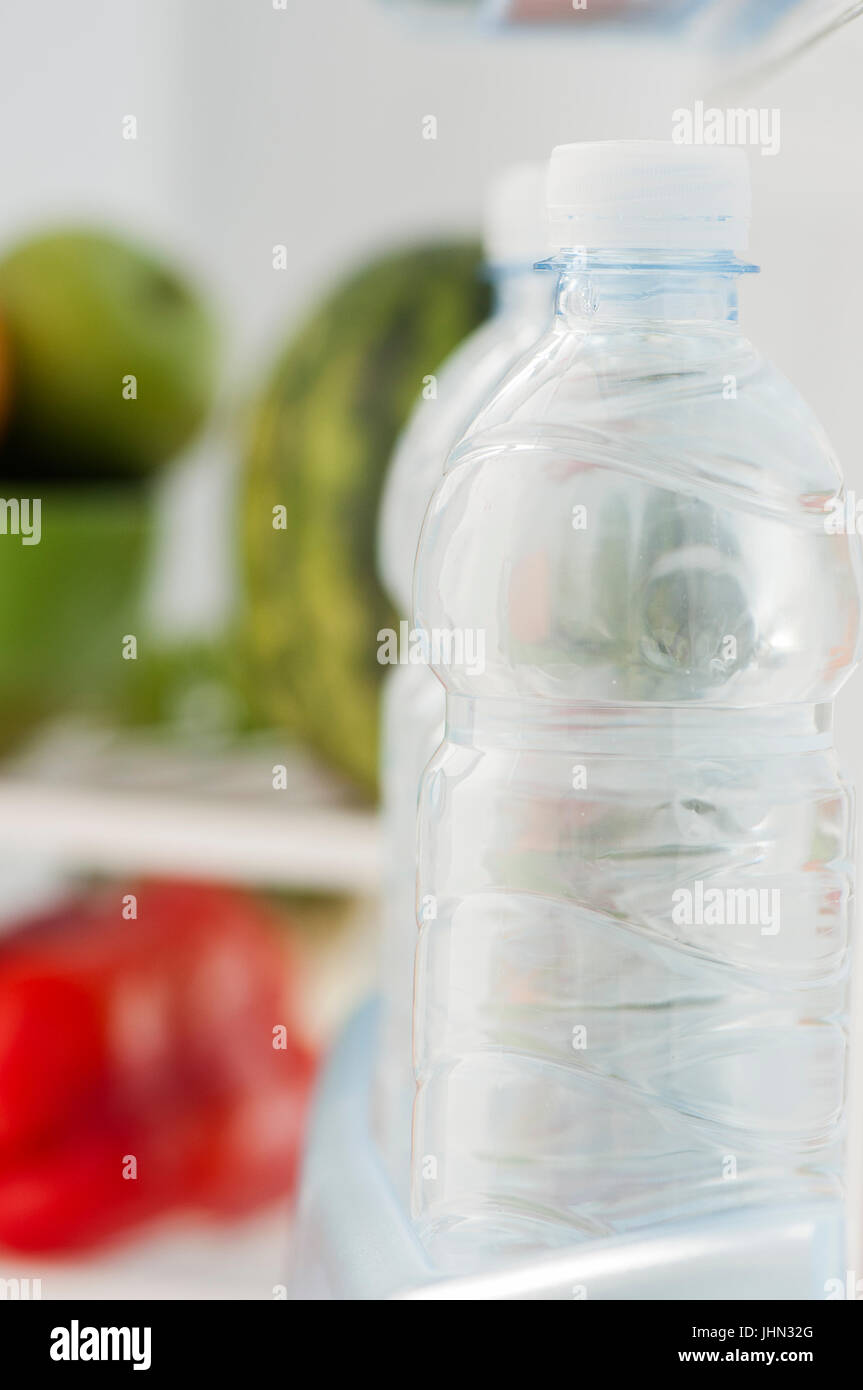 Bottles of cold and refreshing mineral water in refrigerator Stock Photo