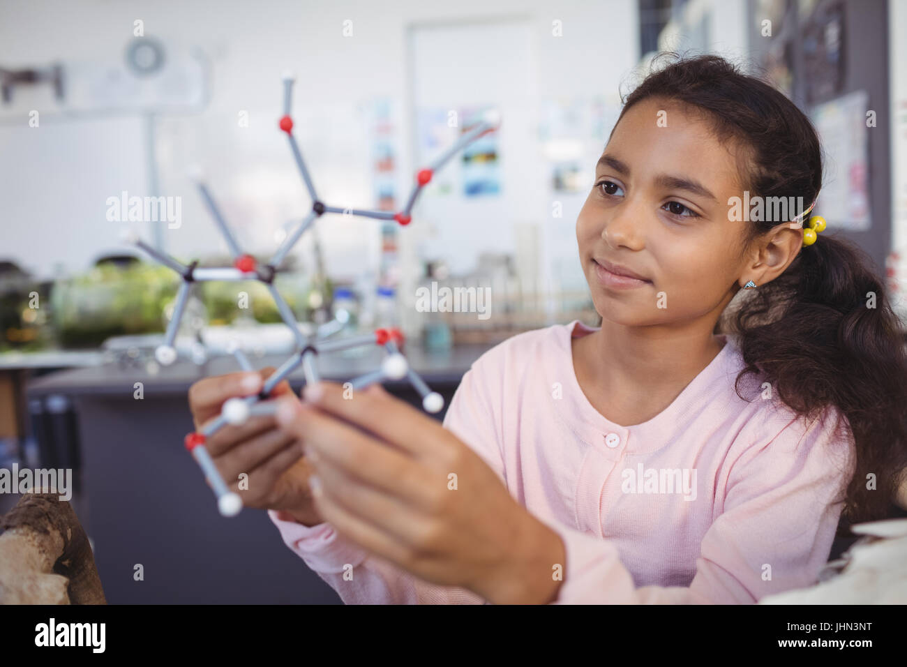 Elementary student examining molecule model at science laboratory Stock Photo