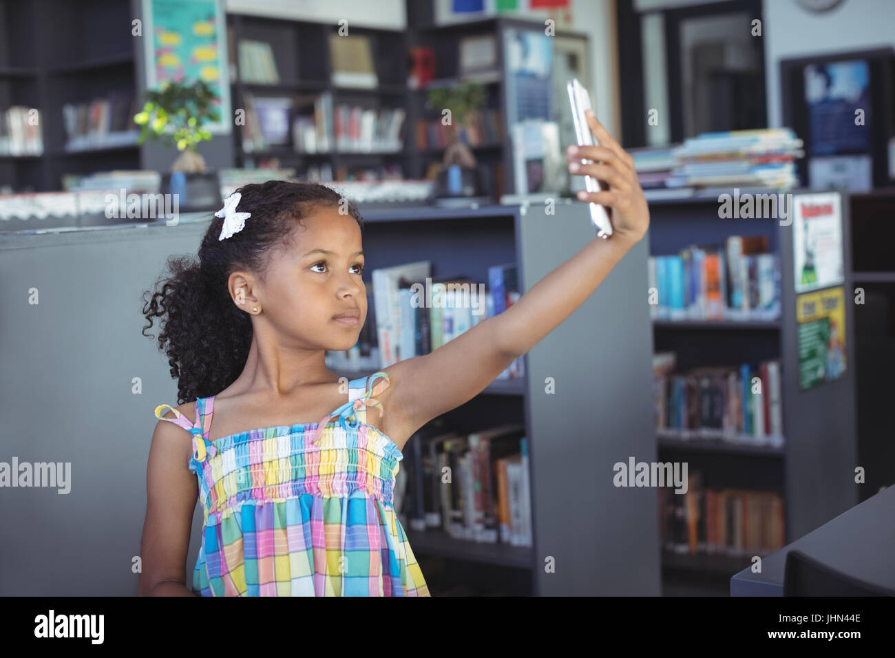 Girl taking selfie while standing in library Stock Photo Alamy