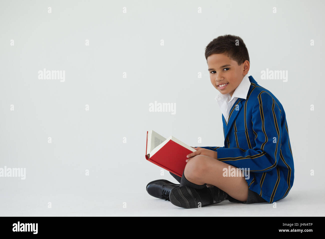 Portrait of schoolboy reading book on white background Stock Photo - Alamy