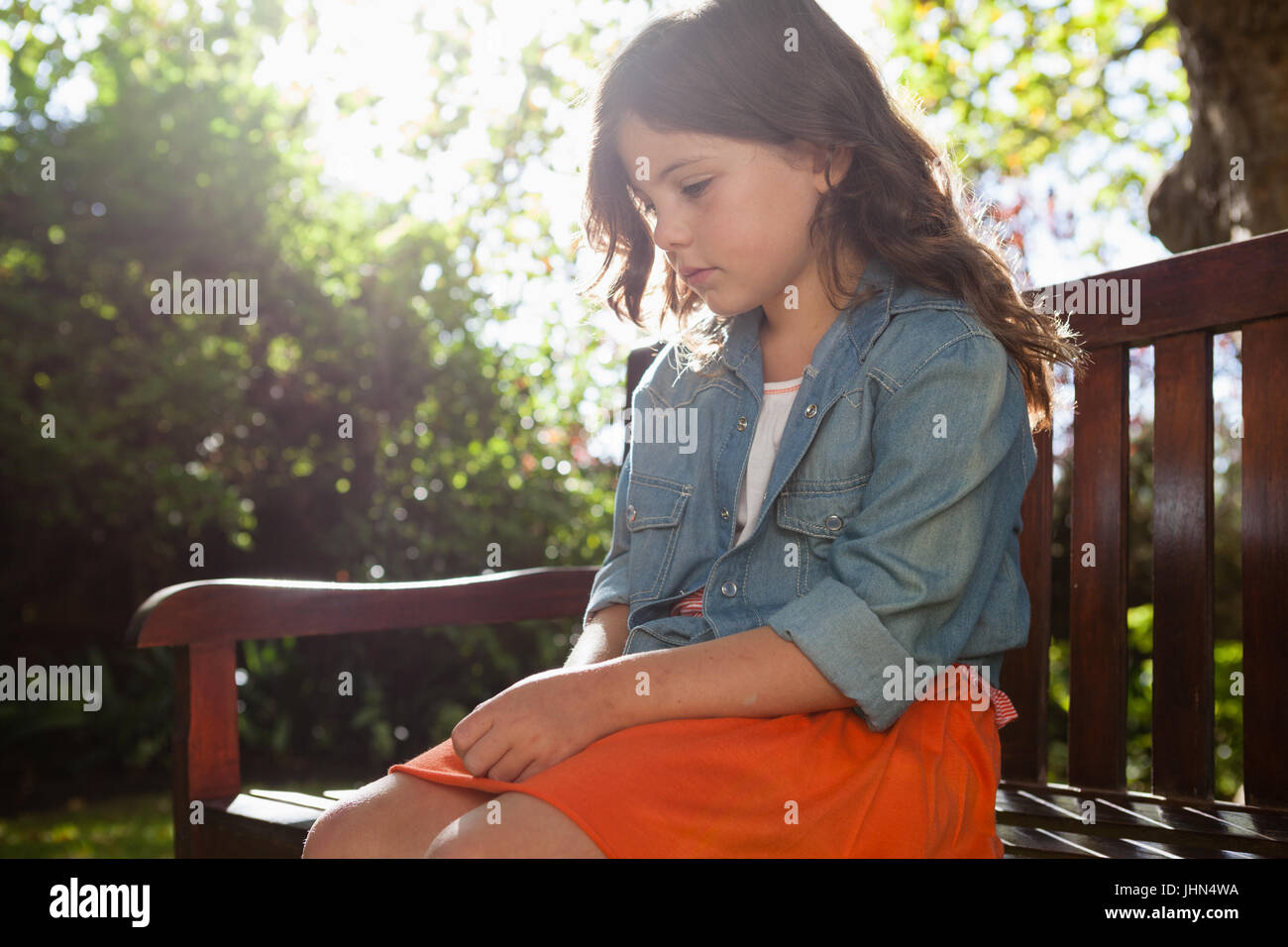Sad girl sitting on bench hi-res stock photography and images - Alamy