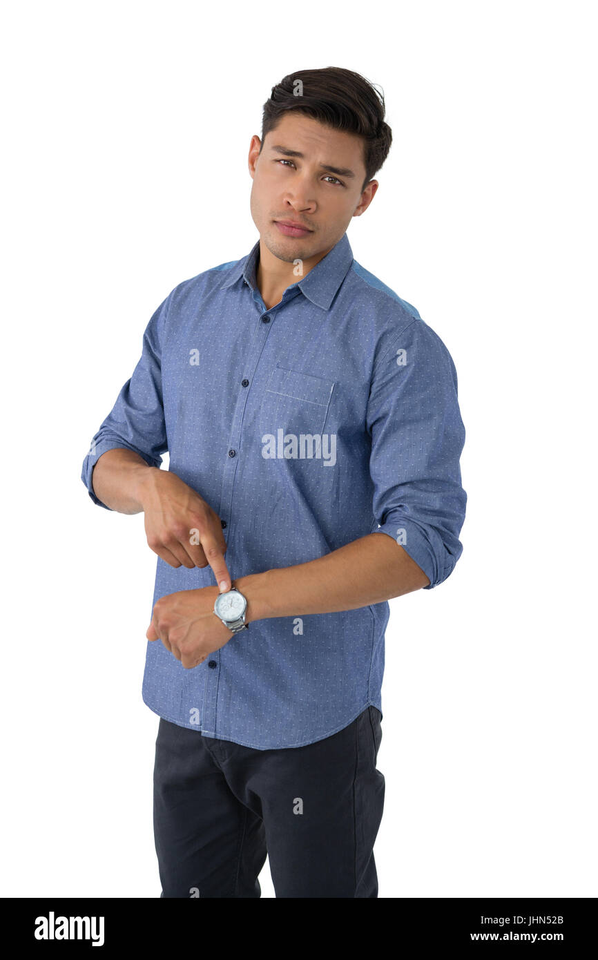 Portrait of young businessman showing time while standing against white background Stock Photo