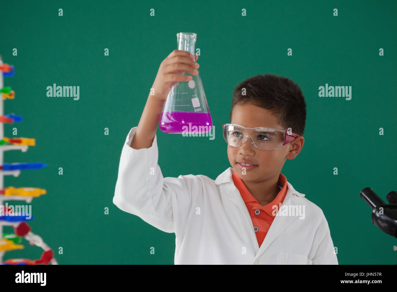 Attentive schoolboy doing a chemical experiment in laboratory at school ...