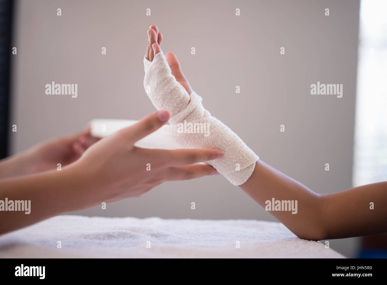 Closeup of female therapist wrapping bandage on hand at hospital ward Stock Photo Alamy