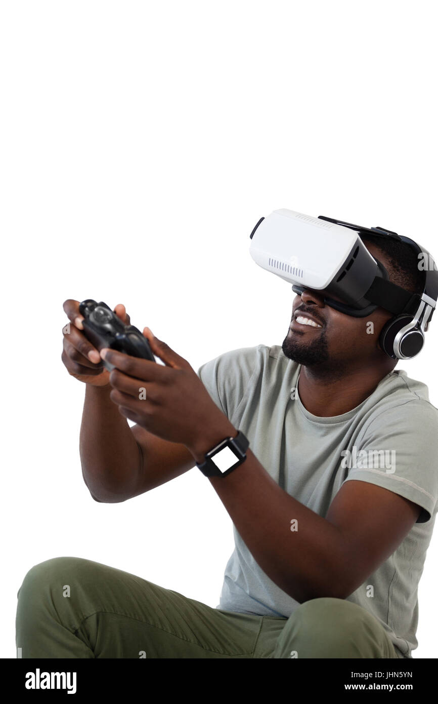 Man using virtual reality headset and playing video game against white ...