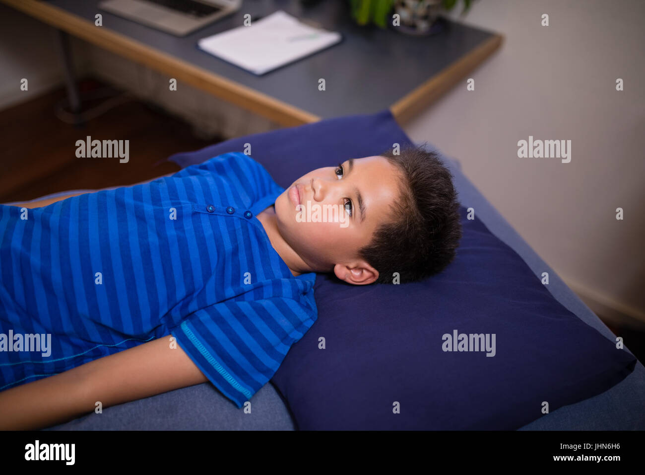 High angle view of boy lying on blue bed at hospital ward Stock Photo