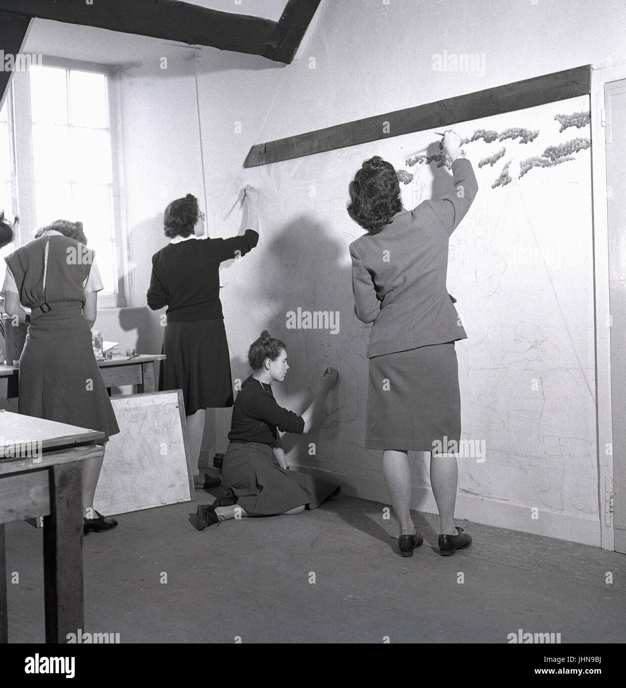 1950s, historical, England, three female students painting a large scale wall artwork for an art course at a teacher training college. Stock Photo