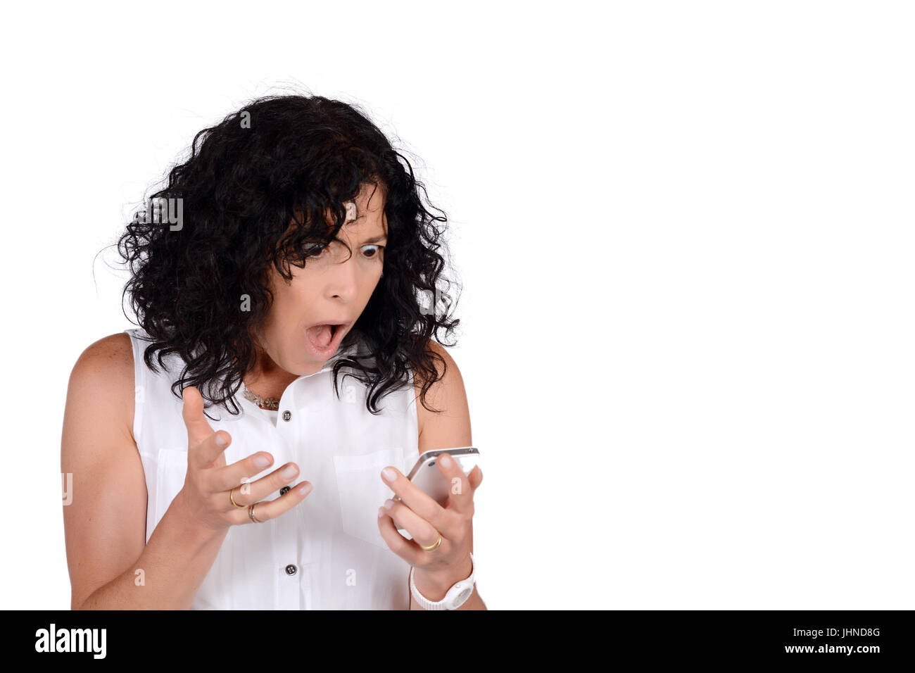 Portrait of beautiful woman looking surprised to phone. Isolated white ...