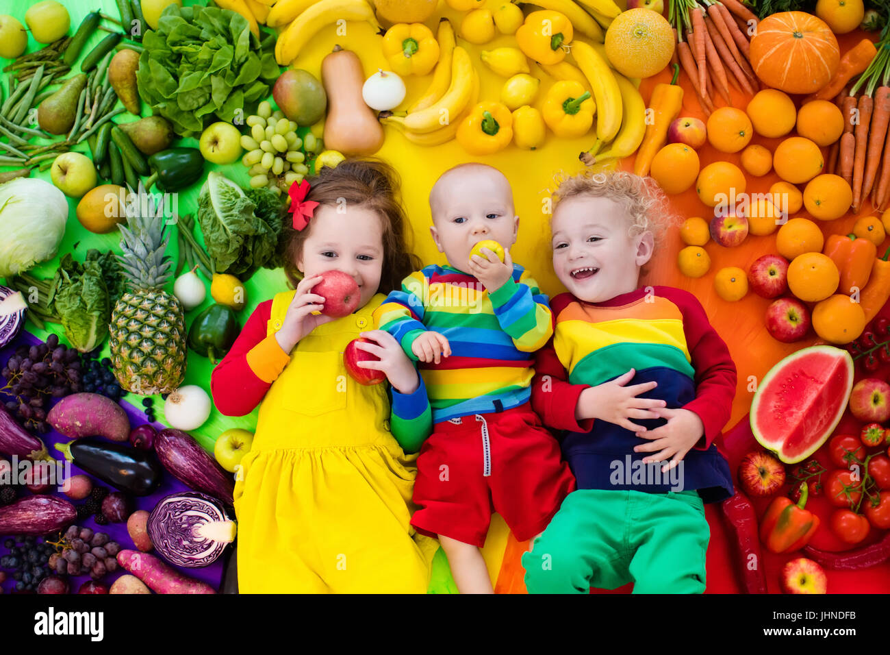 Boy, girl and baby with variety of fruit and vegetable. Colorful