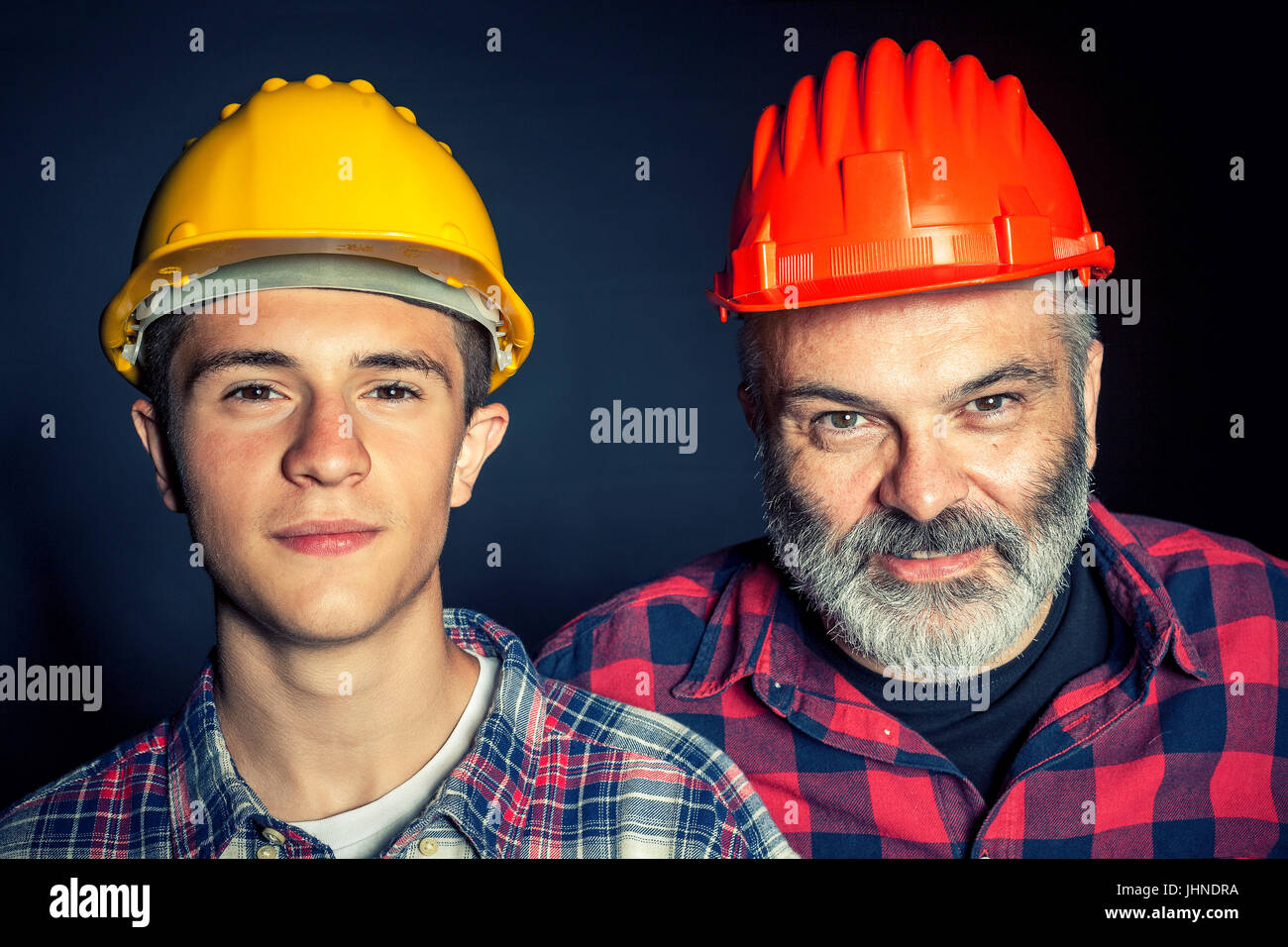father and son with constructor protection helmet Stock Photo