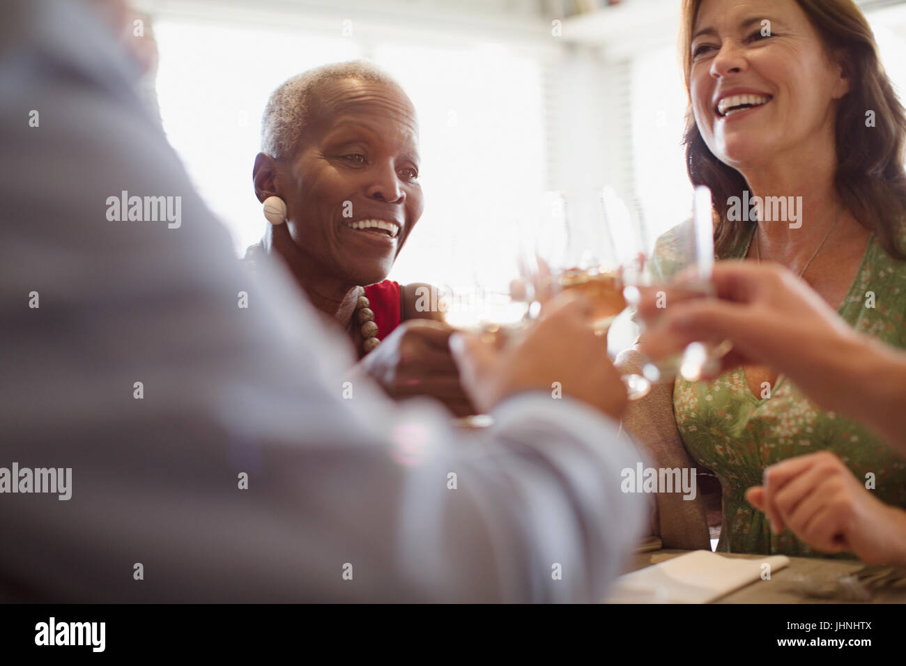 Smiling mature women drinking wine, dining at restaurant Stock Photo