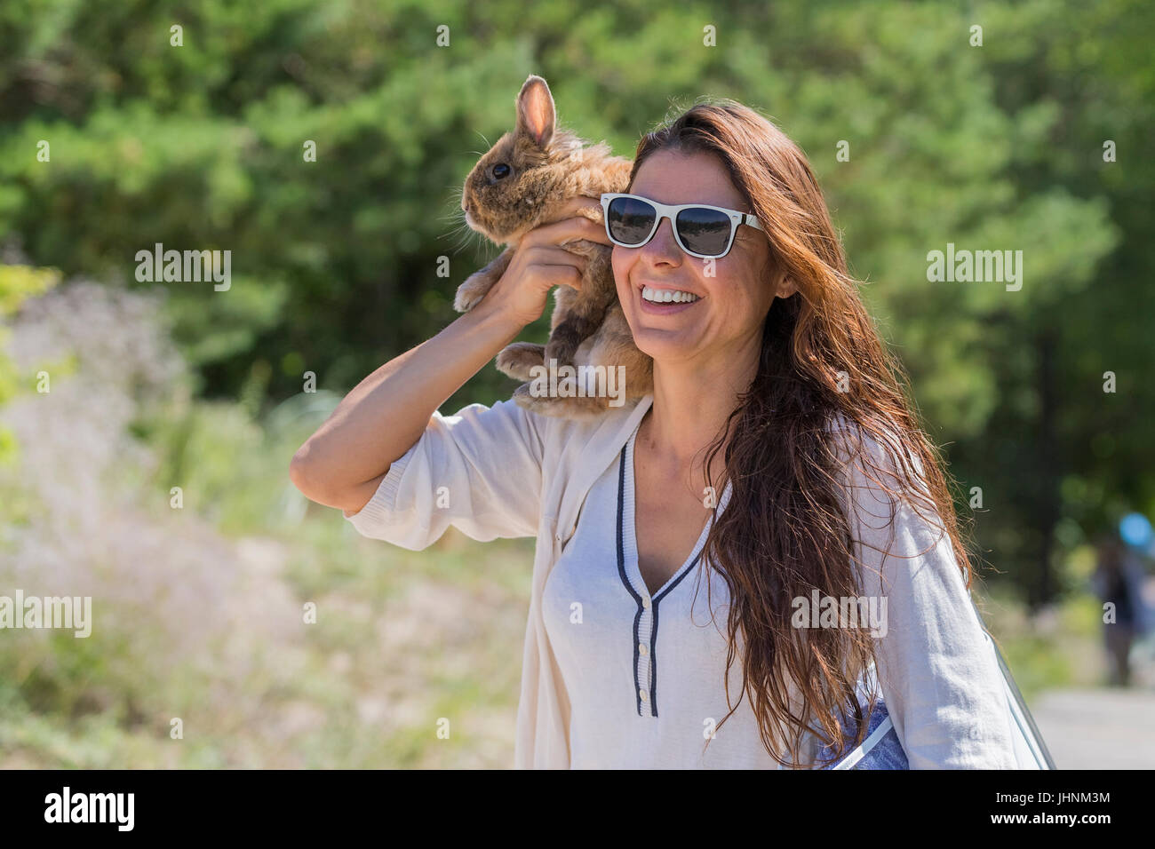 A brunette woman with a rabbit on a walk Stock Photo - Alamy