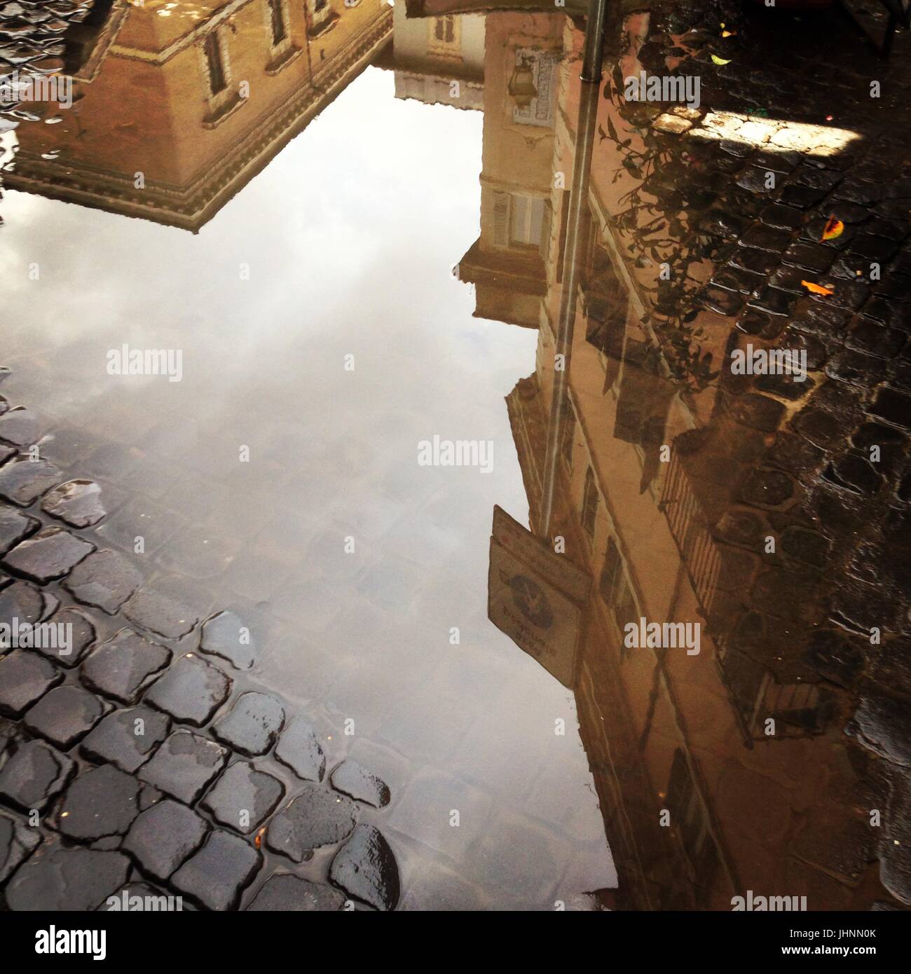 Buildings reflected in a puddle of water in Rome, Italy Credit © Anna ...