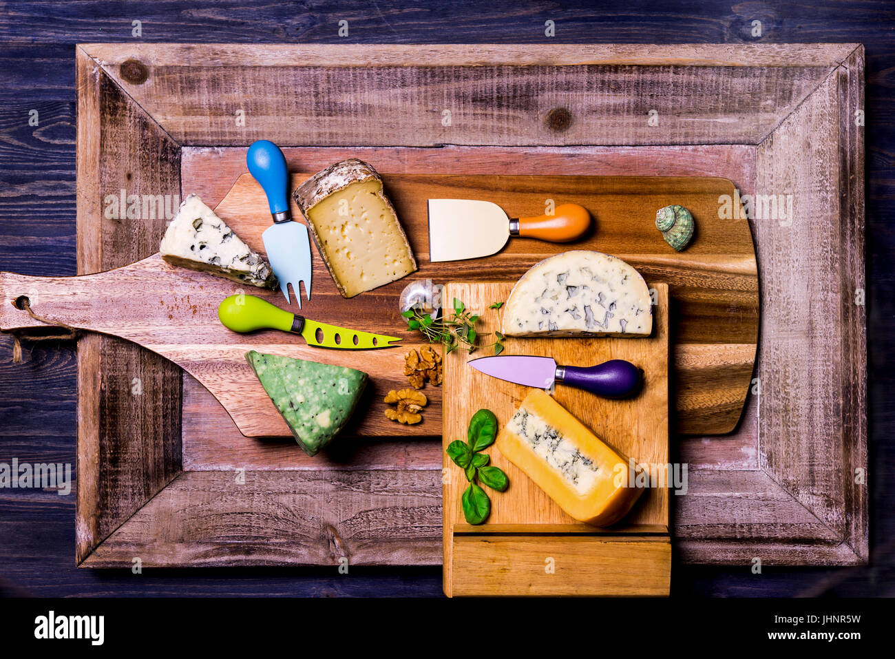 English and French cheese on wooden boards, knives for cheese Stock Photo