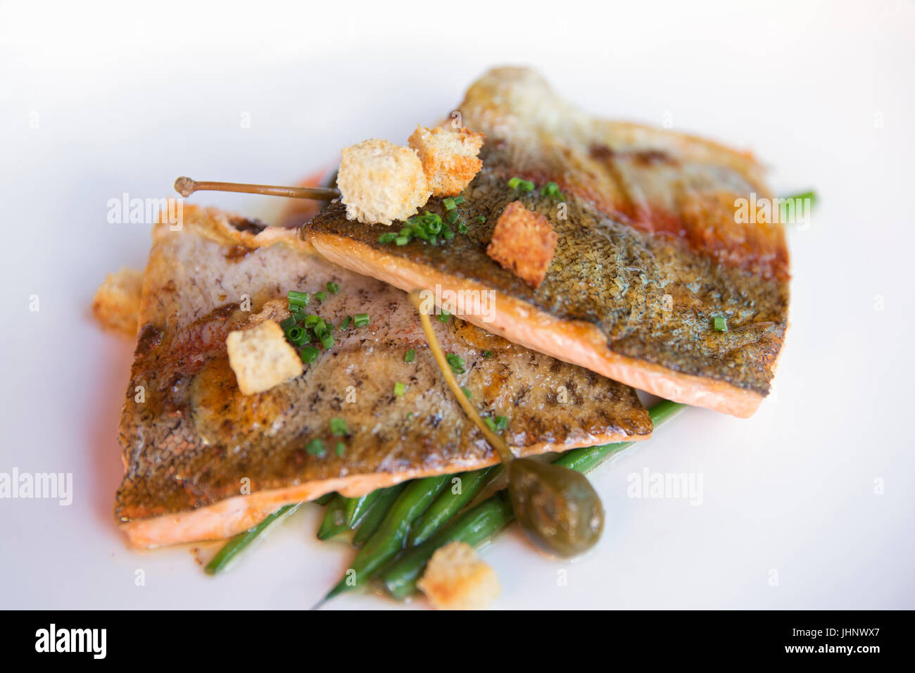 trout dinner on a white plate at the Blumenthal restaurant Stock Photo