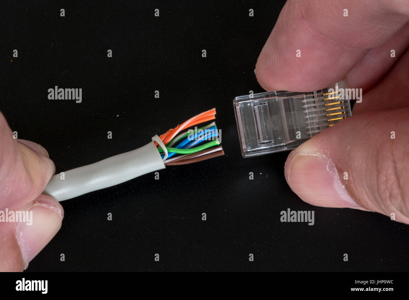 Fitting an RJ45 plug to the end of an Ethernet cable. Stock Photo