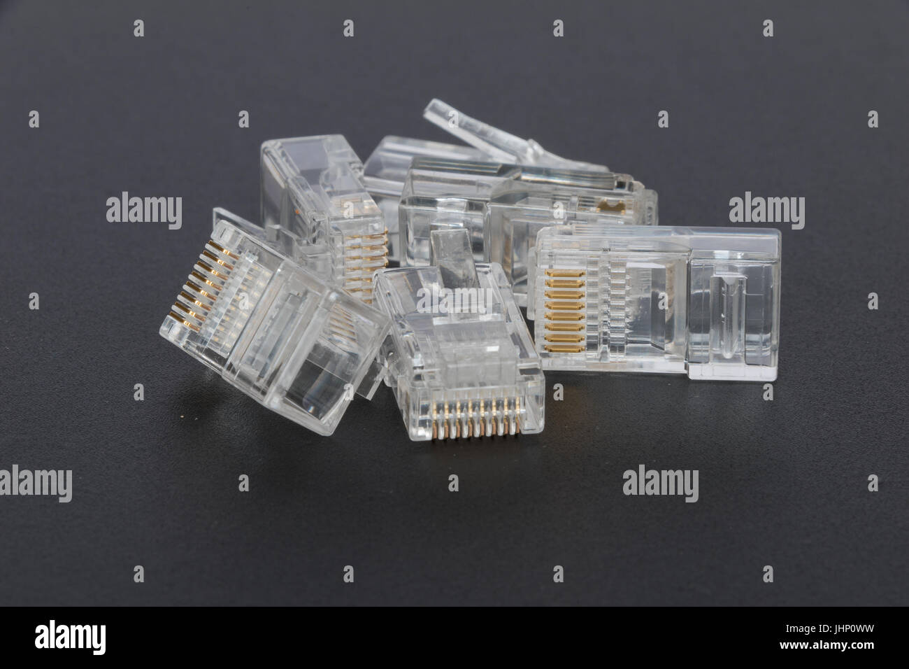 Blank RJ45 Ethernet plugs on a black background Stock Photo