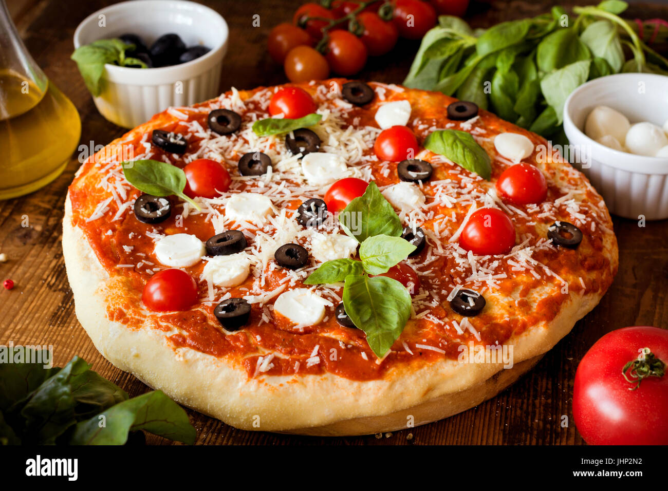 Homemade italian pizza on wooden table. Closeup view Stock Photo