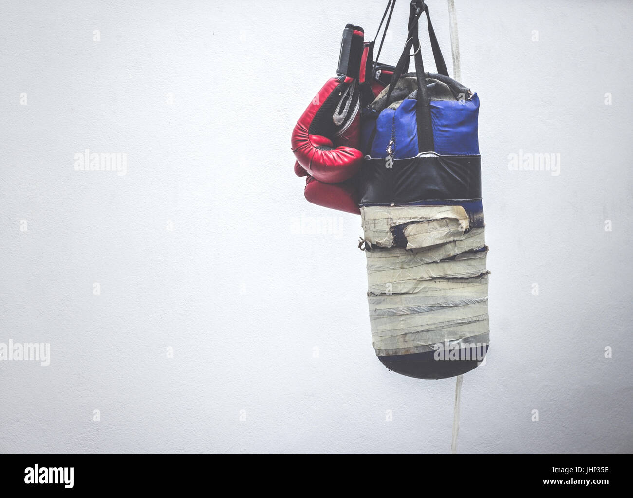 Photograph of an old punching bag and a pair of boxing gloves Stock Photo