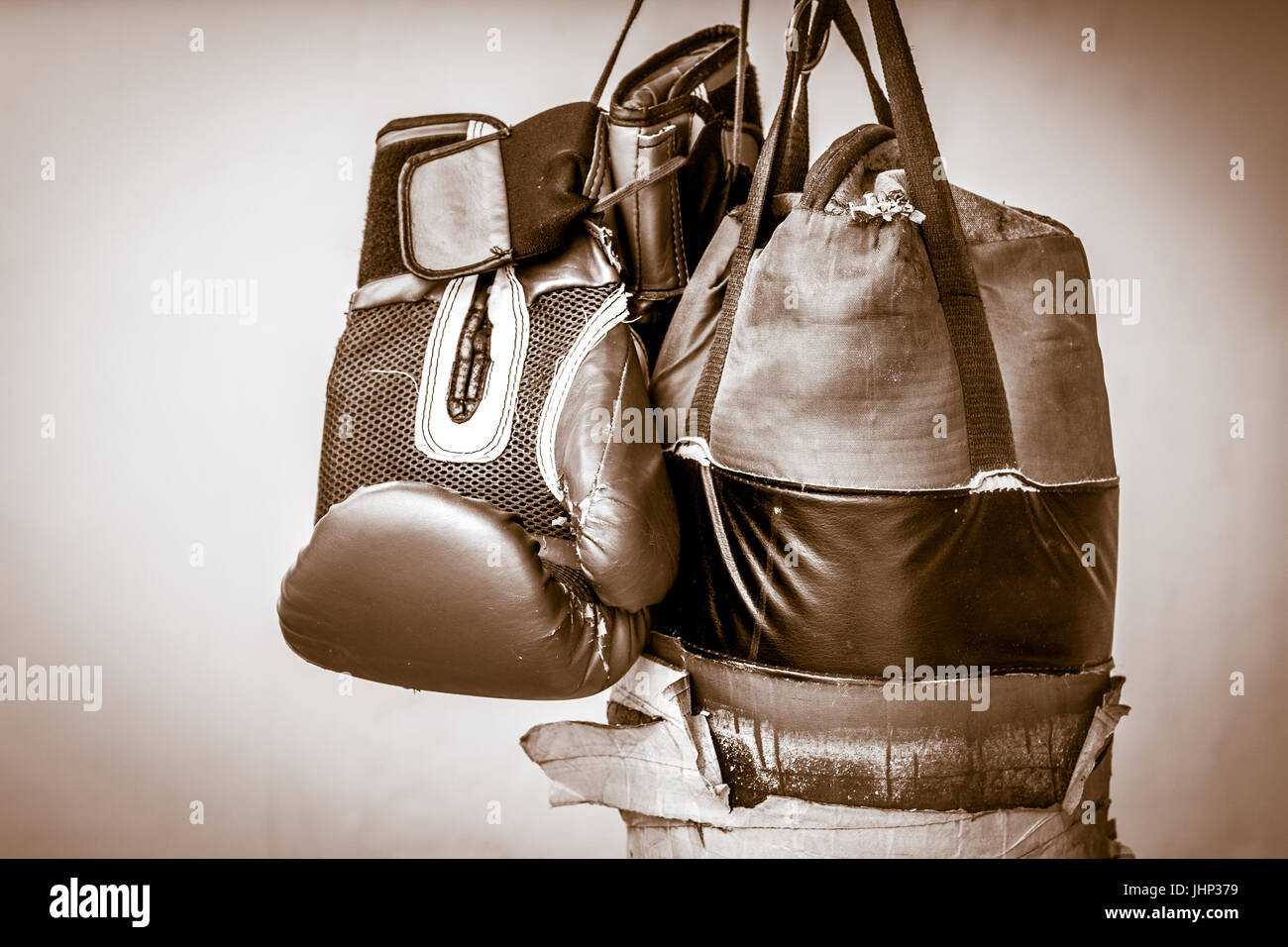 Photograph of an old punching bag and a pair of boxing gloves Stock Photo