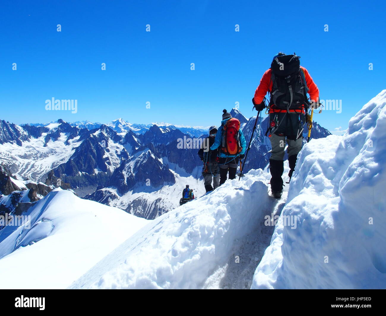 Four alpinists and mountaineer climber on AIGUILLE DU MIDI, CHAMONIX MONT BLANC french ALPS, top alpine mountains range landscape, FRANCE on July 2016 Stock Photo