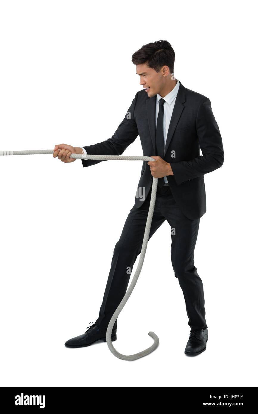 Pulling Against Rope Full length of businessman pulling rope while standing against white ...