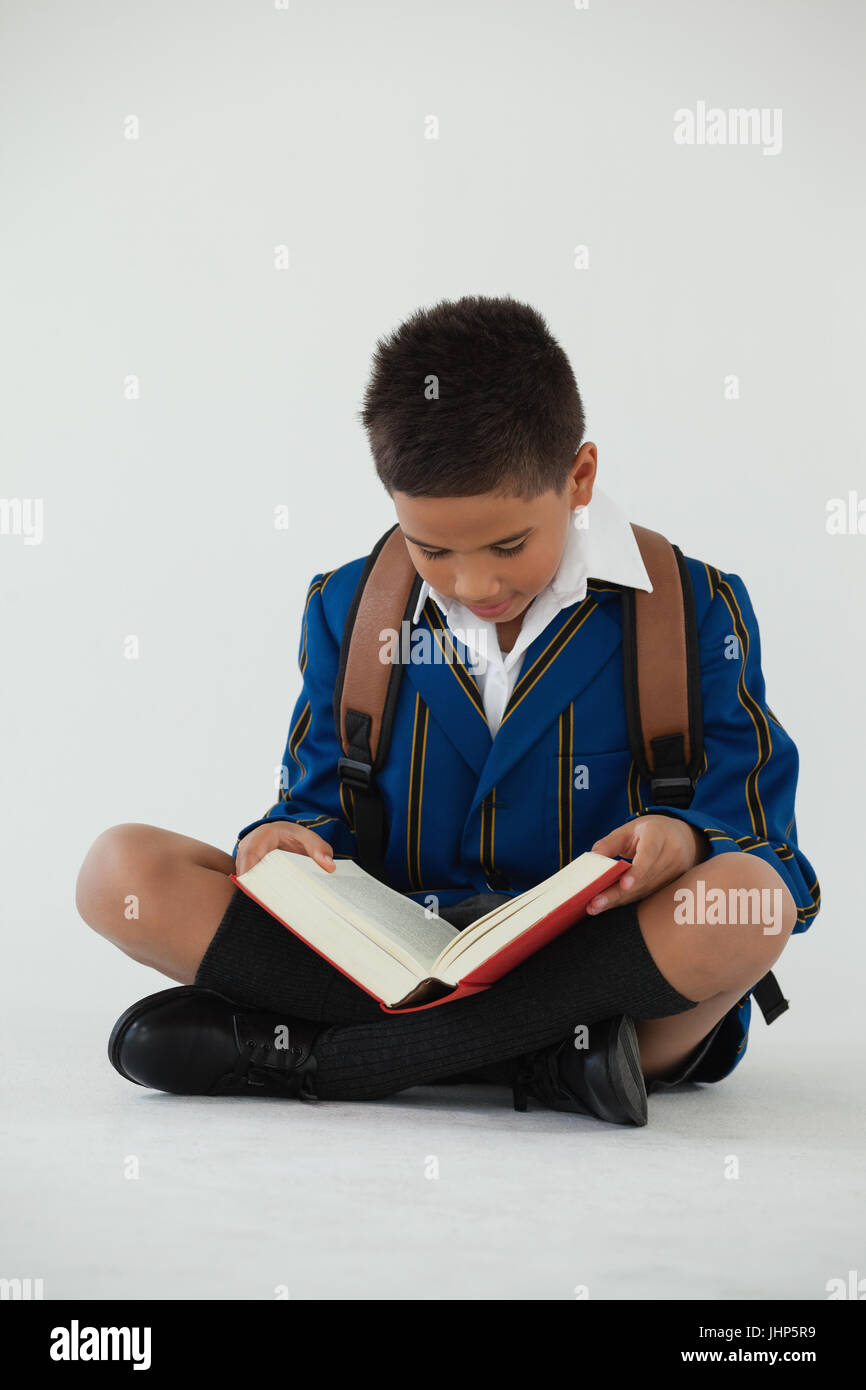 Attentive schoolboy reading book on white background Stock Photo - Alamy