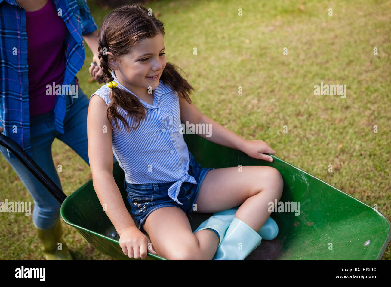 High angle view of mother pushing smiling daughter sitting in ...