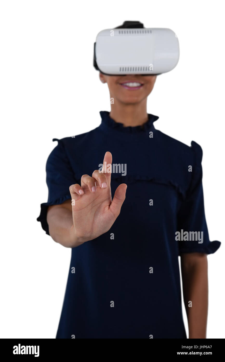 Woman gesturing while using virtual reality headset against white ...