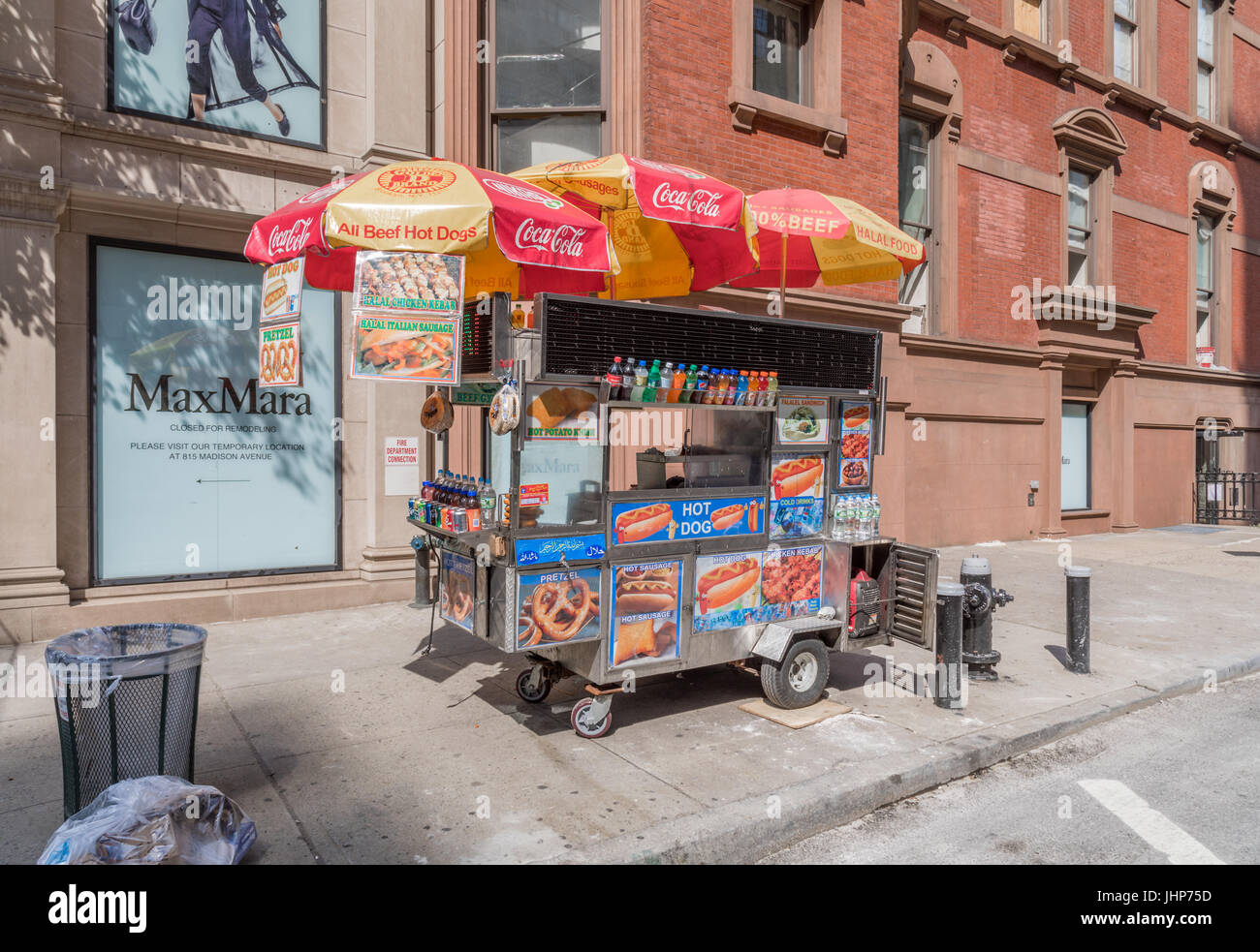 a colorful hot dog cart on the upper east side of Manhattan with a building behind Stock Photo