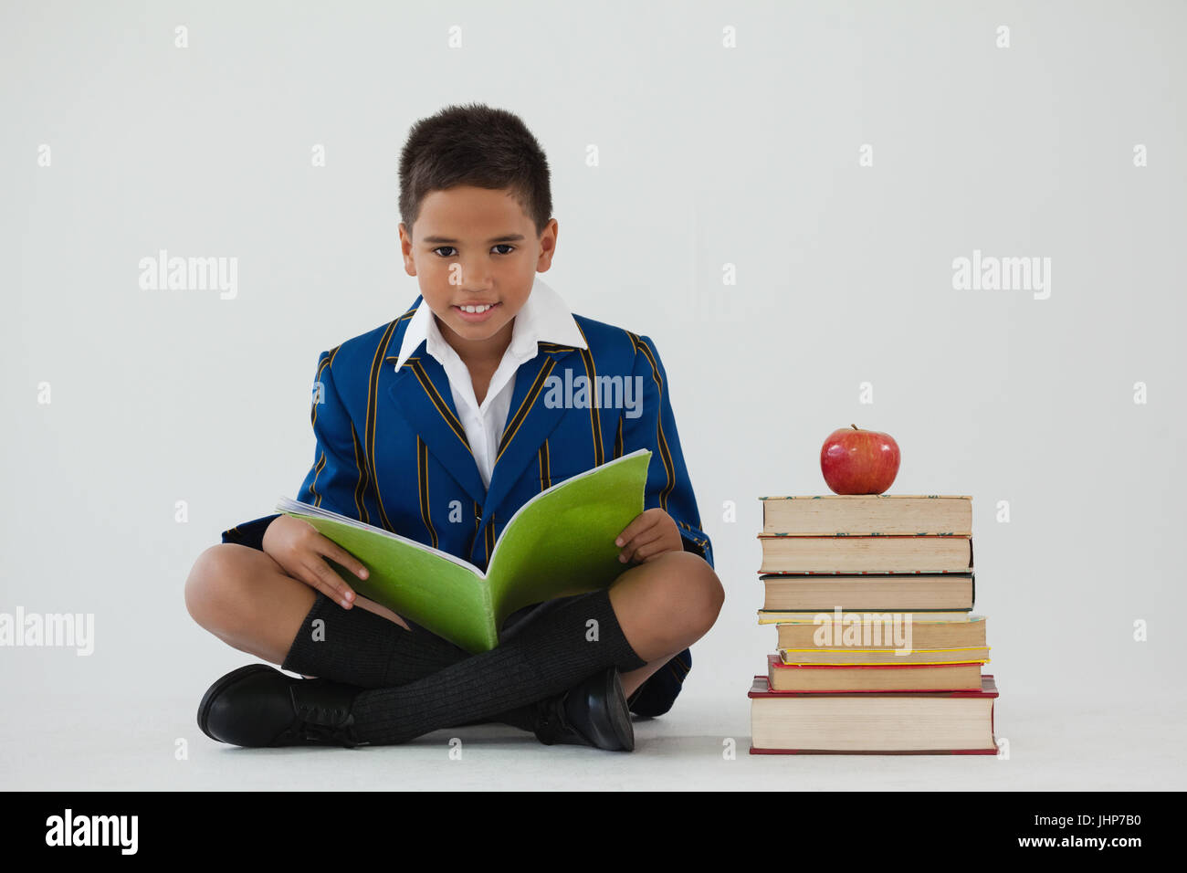 Portrait of schoolboy studying against white background Stock Photo - Alamy