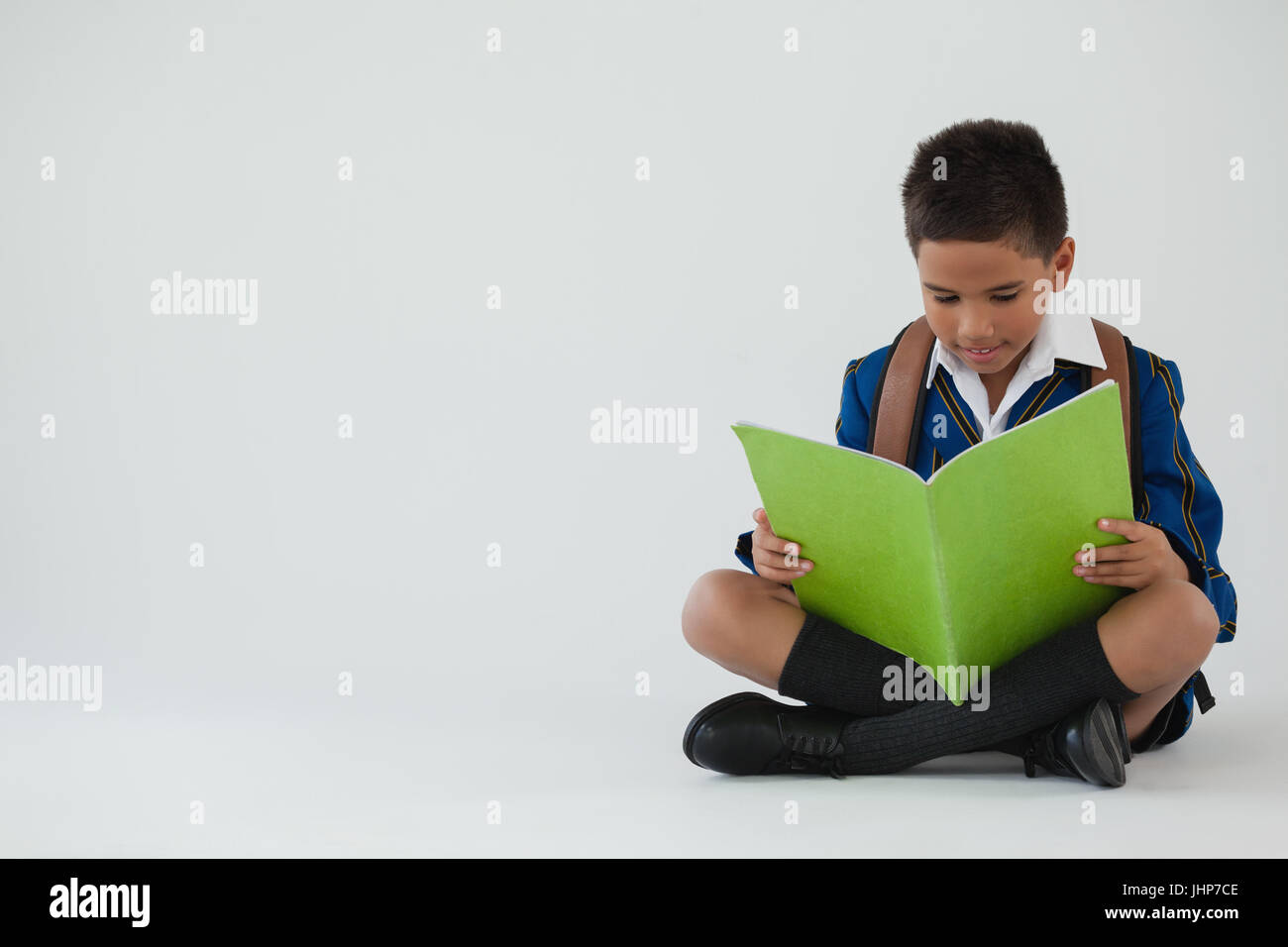 Attentive schoolboy reading book on white background Stock Photo - Alamy