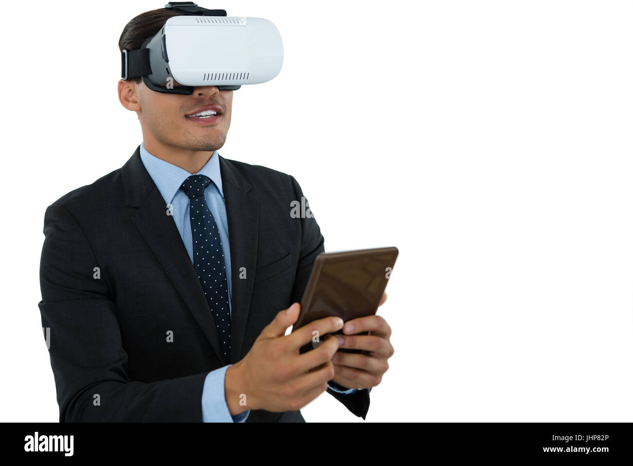 Businessman wearing vr glasses while using tablet against white background Stock Photo