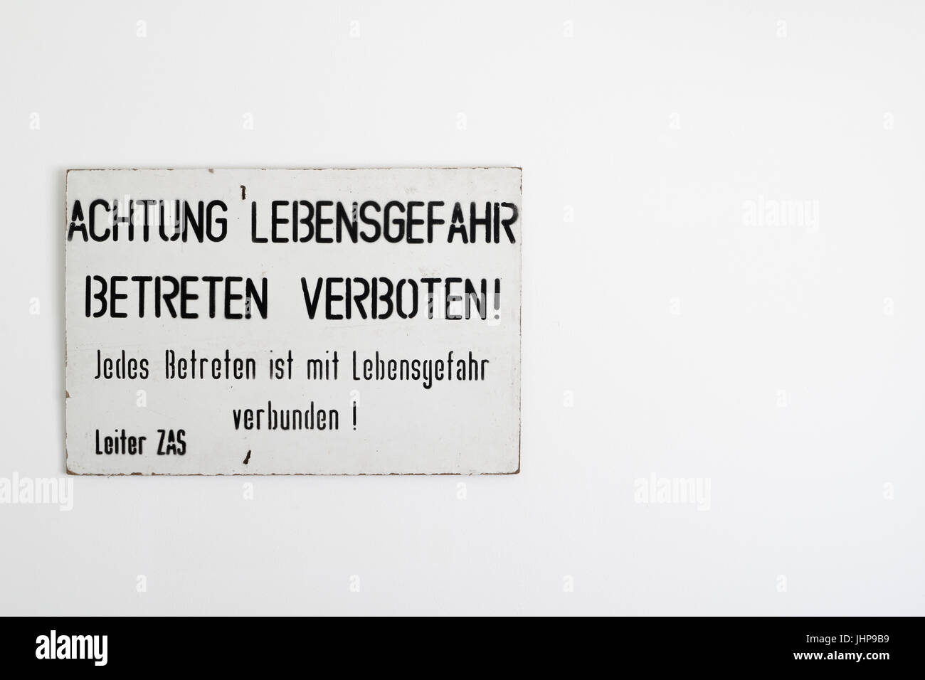 East - West German border warning sign on a white wall with copy space. Found following the reunification of Germany at the end of the Cold War. Stock Photo