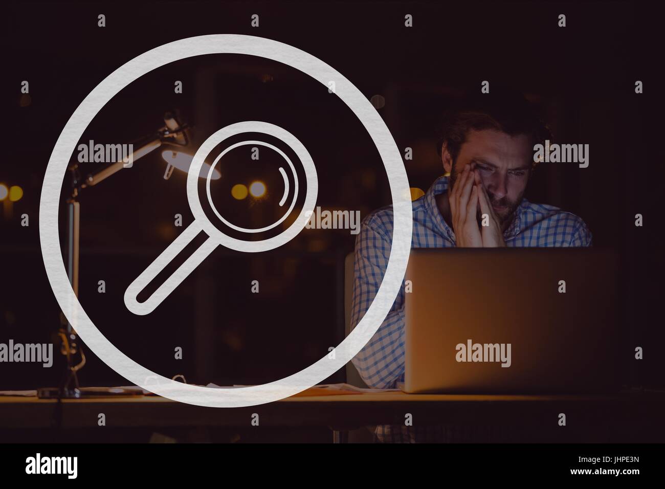 Digital composite of Magnifying glass icon against man using a computer ...