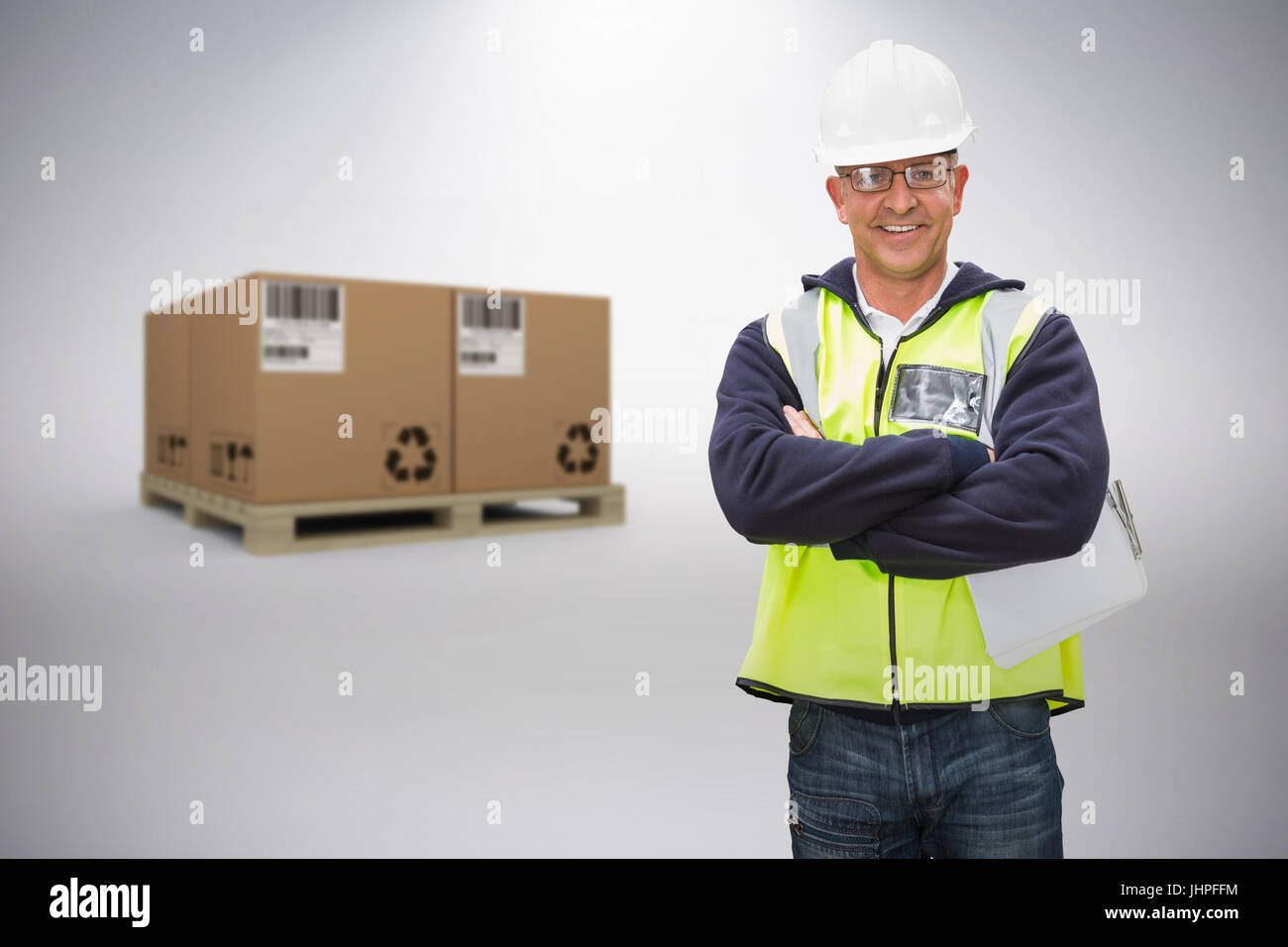 Worker wearing hard hat in warehouse against grey background Stock