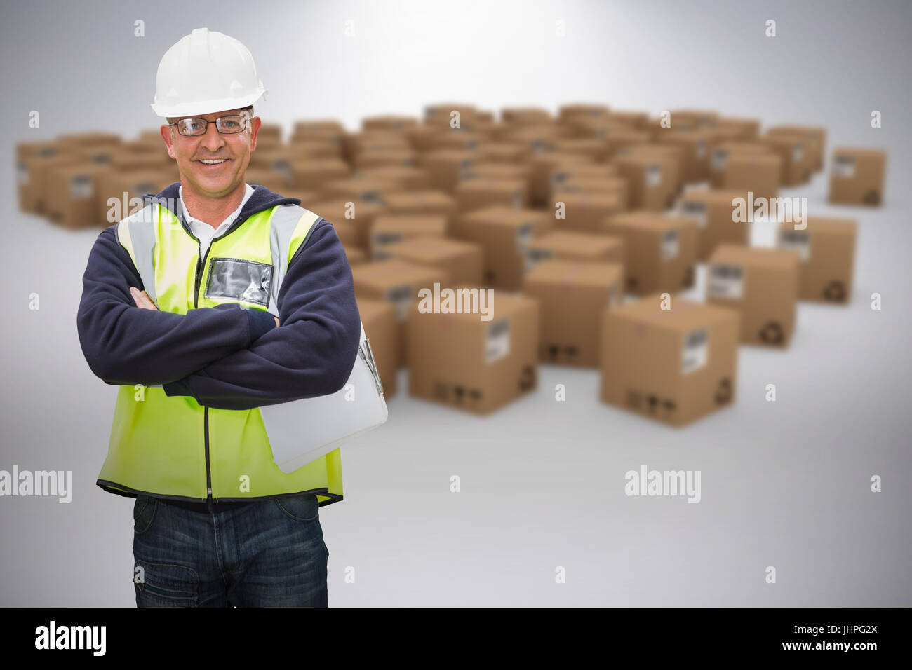 Worker wearing hard hat in warehouse against grey background Stock