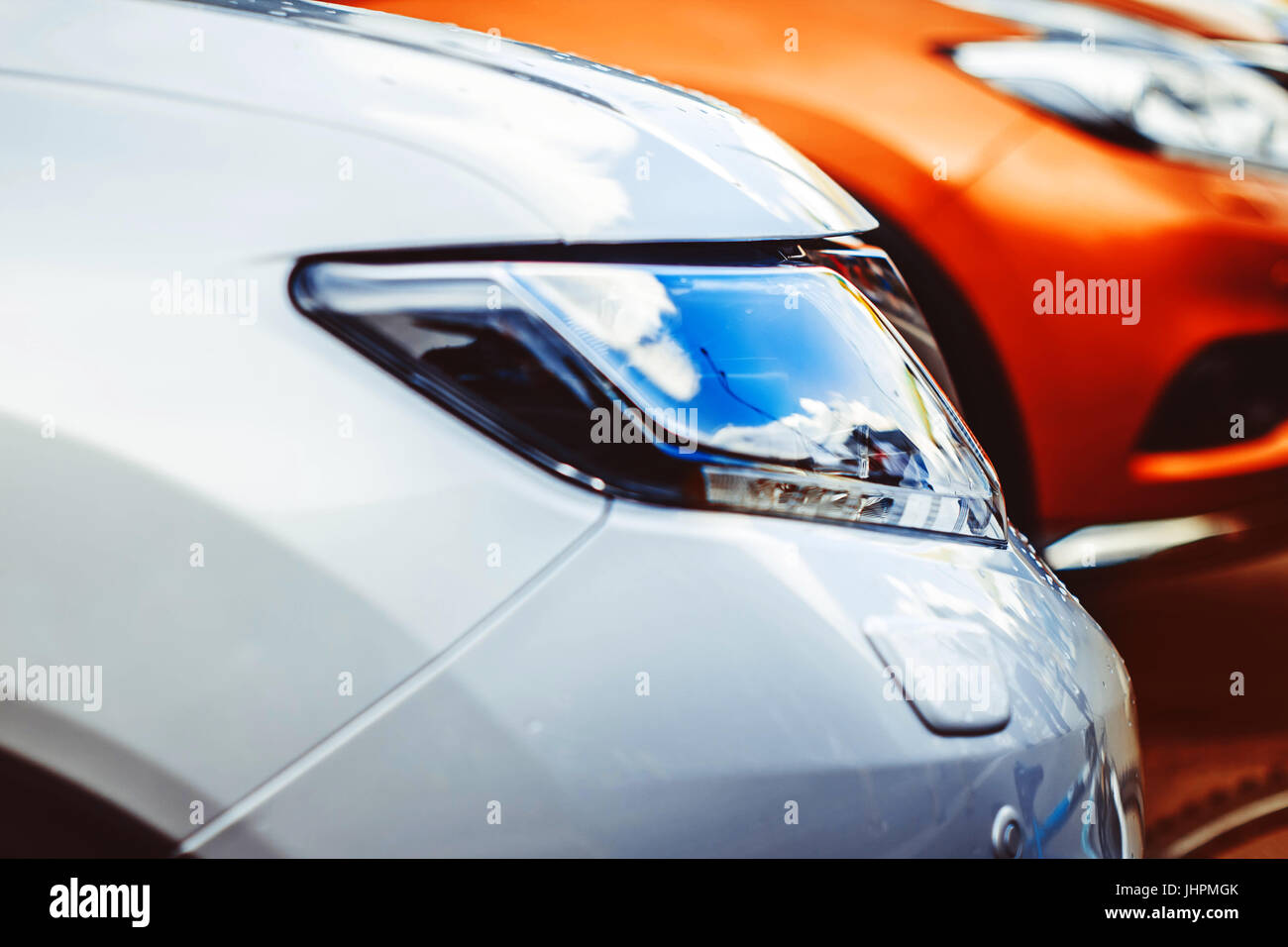 colorful headlights of white car after the rain at night on car parking ...