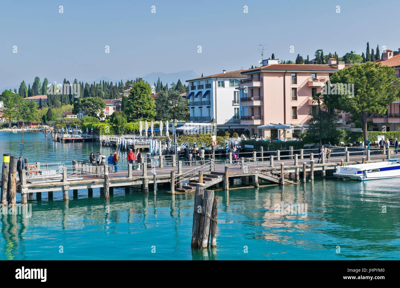 LAKE GARDA SIRMIONE LAKESIDE FRONT APPROACHED BY BOAT WITH PASSENGERS WAITING ON THE JETTY Stock Photo