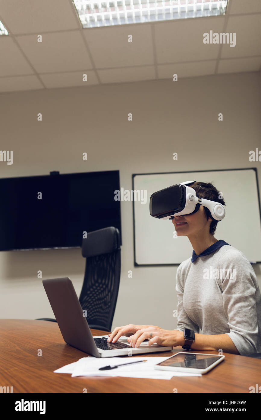 Businesswoman using virtual reality headset in office Stock Photo - Alamy