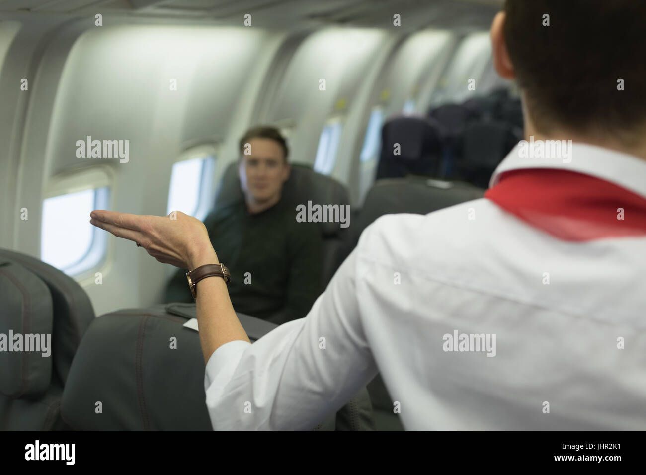Air hostess gives safety instructions on board in an aircraft Stock Photo