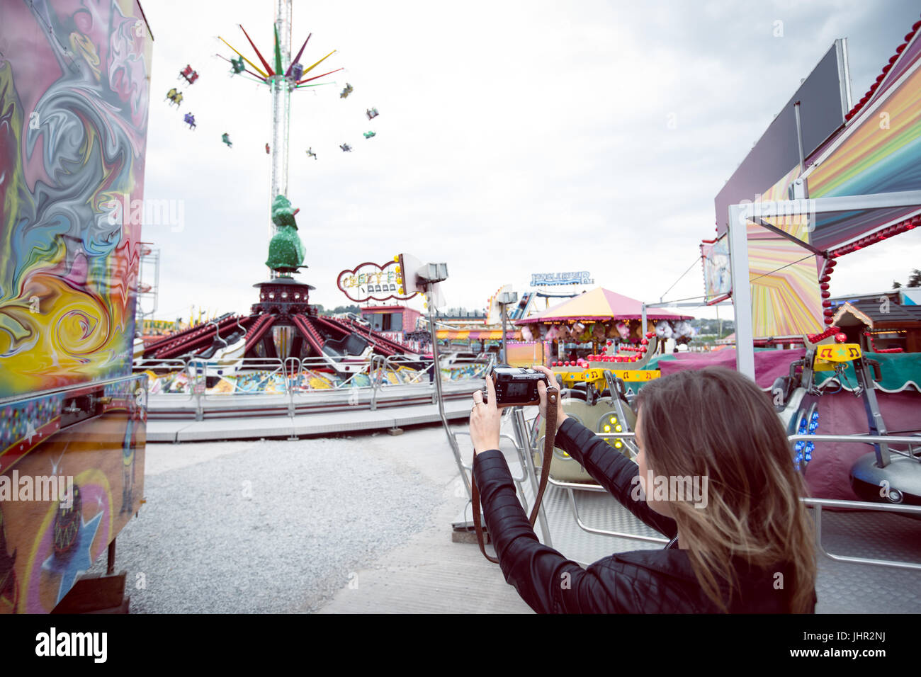 Woman clicking picture with digital camera in amusement park Stock Photo
