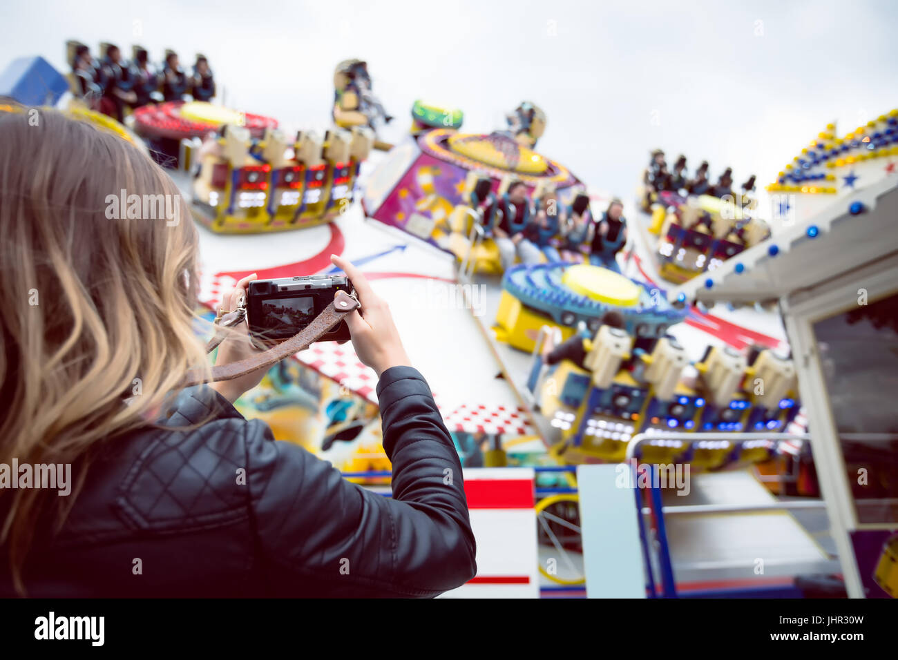 Woman clicking picture with digital camera in amusement park Stock Photo