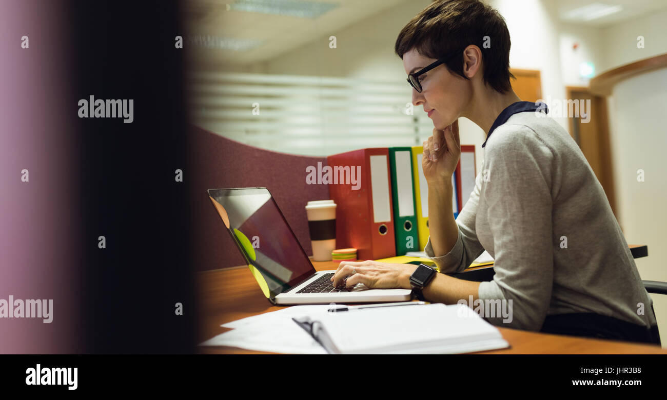Businesswoman working at her desk in office Stock Photo - Alamy