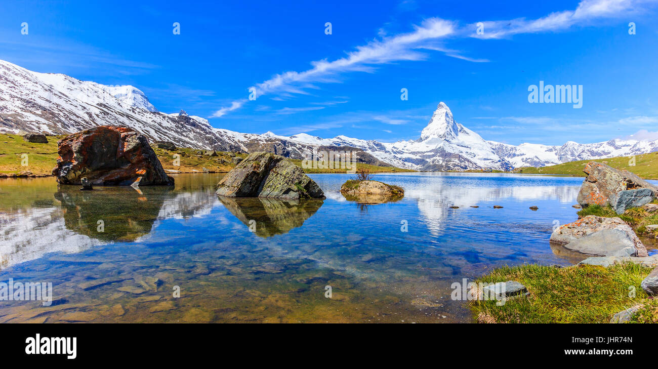 Beautiful panoramic summer view of the Stellisee lake with reflection of the iconic Matterhorn (Monte Cervino, Mont Cervin) and clear blue sky on wate Stock Photo